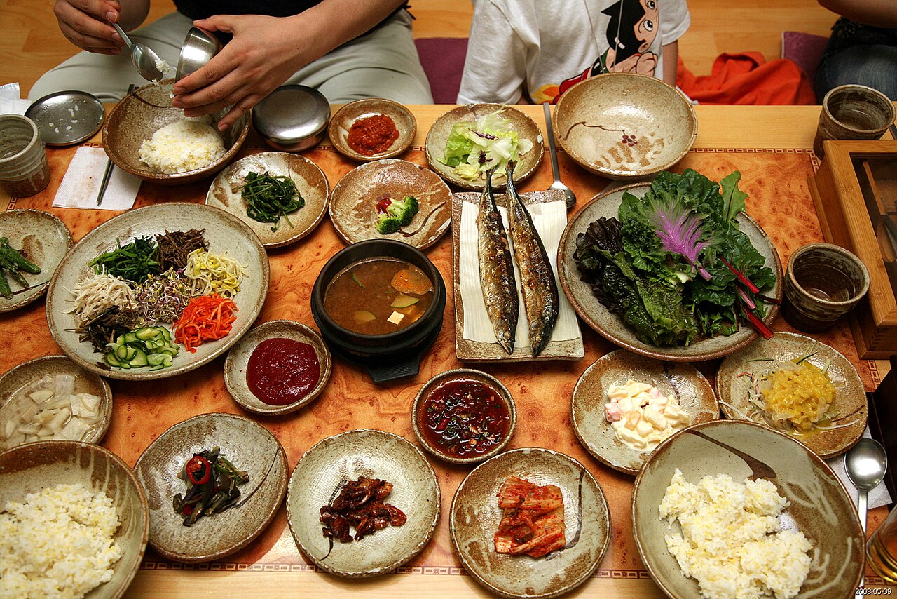 Korean meal with rice wraps and banchan side dishes